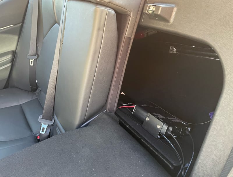 The rear passenger row of the Camry with the pavement-side passenger seat down. Behind it is the ICOM 2730A base unit with a number of cables coming through into the cabin.
