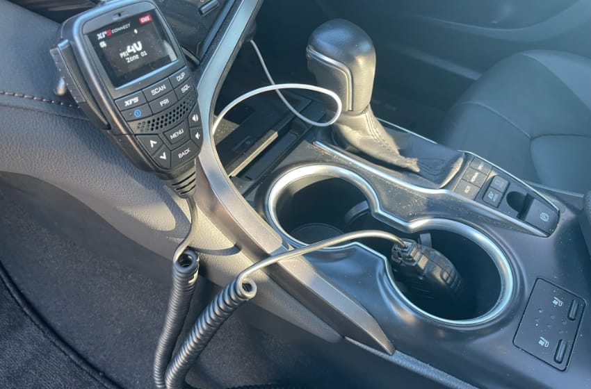 The center console of the vehicle, as seen from the passenger side. The GME speaker/mic is nicely mounted to the dashboard, and the ICOM microphone is unceremoniously dumped into a cup holder.