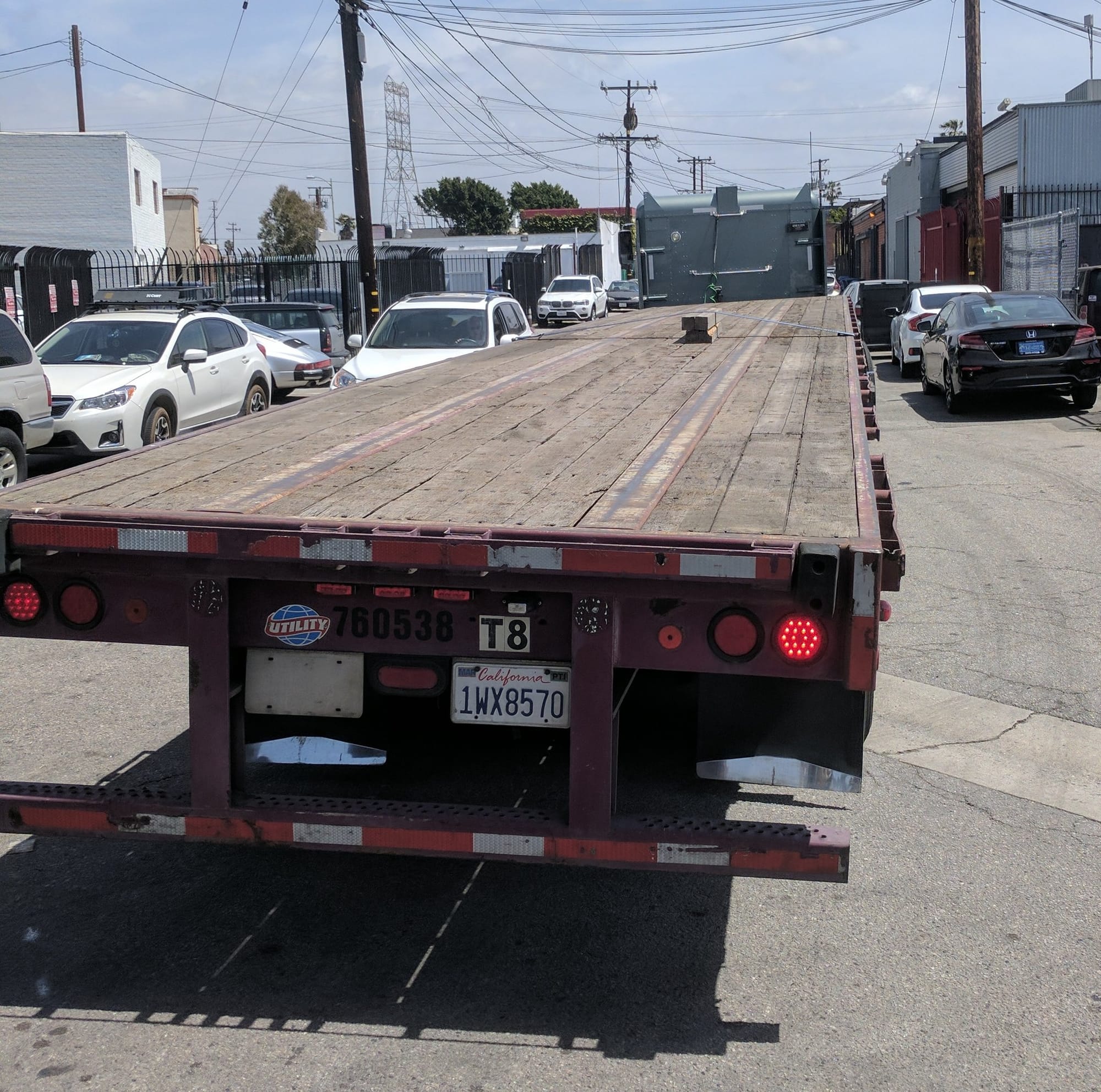 A few small pieces of wood tied down to a large flatbed truck.